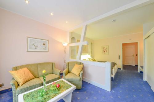 a living room with two chairs and a table at Doerr Landhotel & Spa in Bad Laasphe