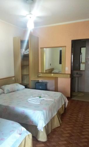 a hotel room with two beds and a mirror at Estancia Montagner in Paulínia
