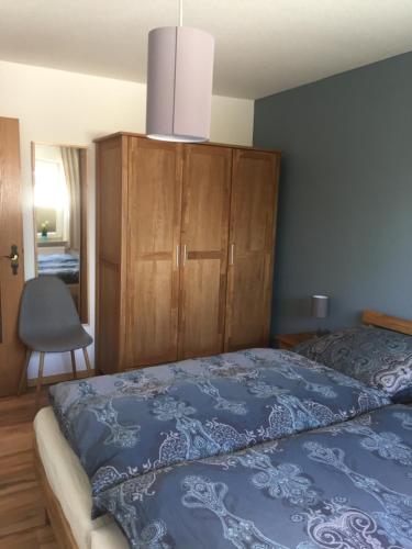 1 dormitorio con 1 cama azul y armario de madera en Hafenperle en Tönning