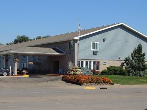 a building with a flag in a parking lot at Governors Inn a Travelodge by Wyndham in Pierre