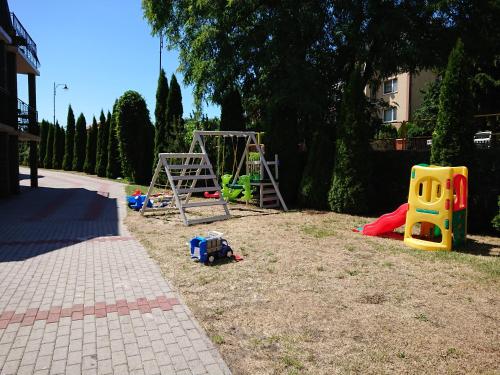 a playground with play equipment in a yard at Grodzisko pokoje do wynajęcia in Krynica Morska