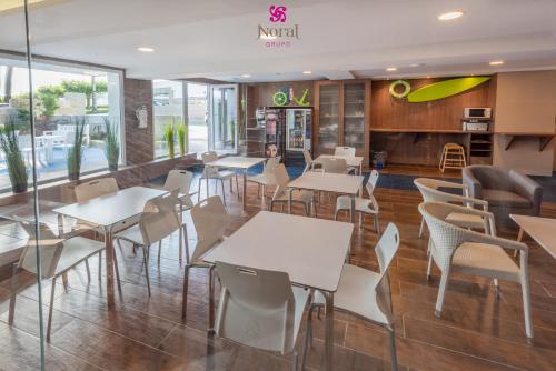 a dining room with tables and chairs in a restaurant at Nuevo Norat Sanxenxo in Sanxenxo