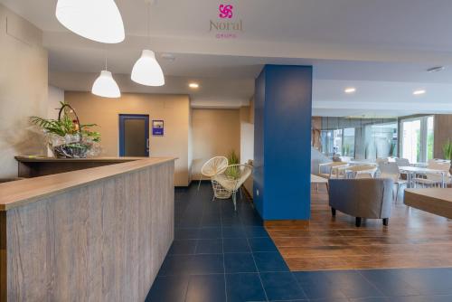 a lobby of a hotel with a bar and tables at Nuevo Norat Sanxenxo in Sanxenxo