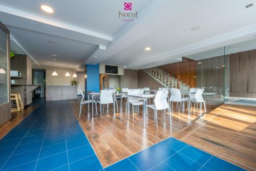a dining room with a table and white chairs at Nuevo Norat Sanxenxo in Sanxenxo
