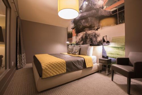 um quarto com uma cama com um quadro na parede em Kinipi Spa Nordique & Hebergement em Trois-Rivières