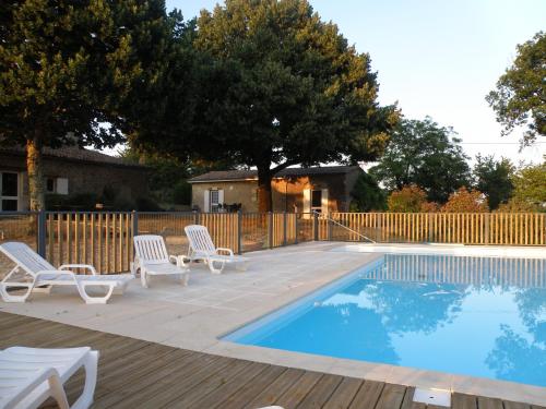 une piscine avec des chaises longues et une clôture dans l'établissement Le Domaine du Bel Air, à Blasimon