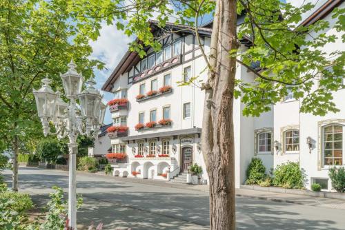 a white building with flower boxes on the windows at Doerr Landhotel & Spa in Bad Laasphe