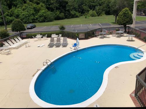 a large swimming pool with chairs and tables and chairs at Motel 6-Memphis, TN - East in Memphis