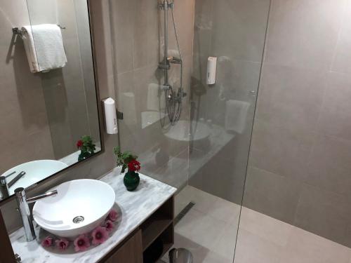 a bathroom with a white sink and a shower at Hotel La Residence Hammamet in Hammamet