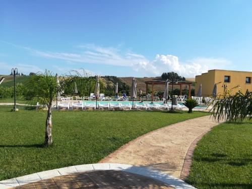 um caminho que leva a uma piscina num parque em Agriturismo l'Olivo em Calatafimi