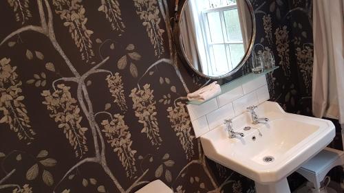 a bathroom with a sink and a mirror at The Old Manse in Lowick