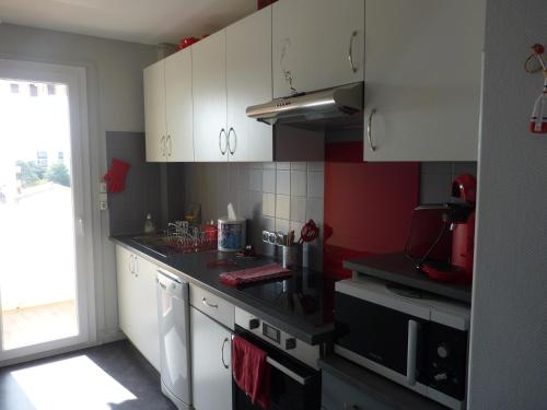 une cuisine avec des armoires blanches et un four à plaques de cuisson dans l'établissement Appartement T3, 6 couchages, Le Montreuil, Narbonne Plage, à Narbonne-Plage