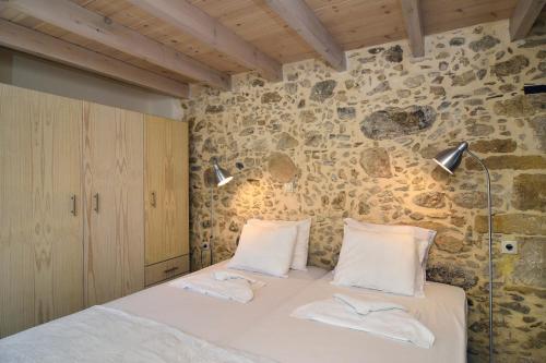 キサモスにあるMousa Thaliaの石壁のベッドルーム1室(ベッド1台付)
