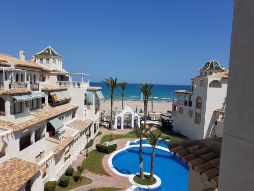 a view of a resort with a swimming pool and the beach at Playa Muchavista lovely ground floor apartment in El Campello