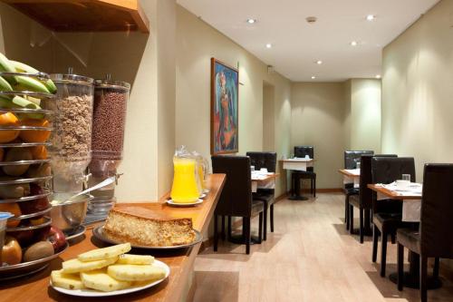 a dining room with a table with food on it at Ateneo Puerta del Sol in Madrid