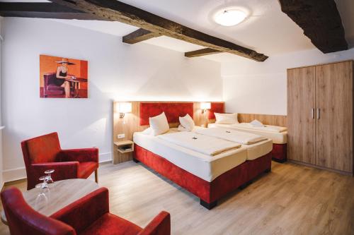 a hotel room with two beds and a chair at Hotel Stadt Kassel in Rinteln
