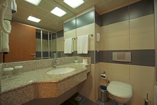 a bathroom with a sink and a toilet and a mirror at Green Nature Resort and Spa in Marmaris