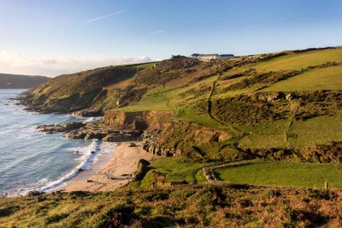 a view of a beach and the ocean on a hill at Gara Rock in Salcombe