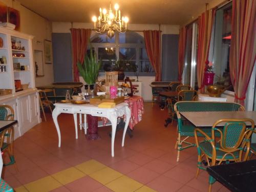 een eetkamer met een witte tafel en stoelen bij La Croix Blanche in Montrichard