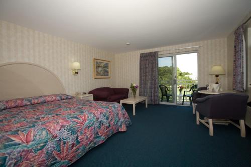 Habitación de hotel con cama y balcón en Winnapaug Inn, en Westerly