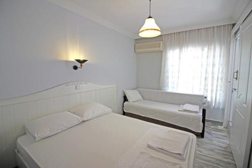 a white room with a bed and a couch at Hambarlı Otel in Bozcaada