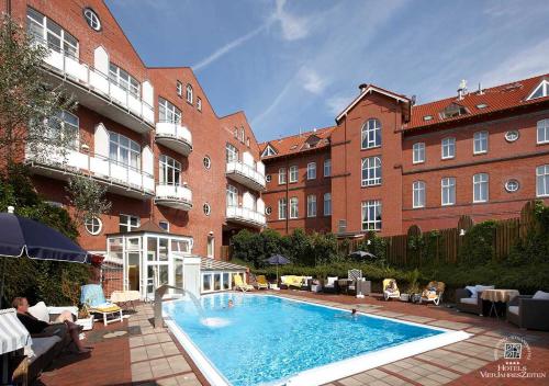 a large swimming pool in front of a building at Inselhotel VierJahreszeiten in Borkum