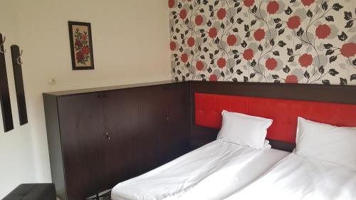 a bedroom with two beds and a red headboard at Hotel Alegra in Velingrad