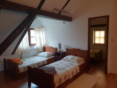 a bedroom with two beds and two windows at Seoski turizam Sumak in Miljana