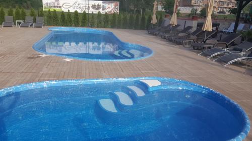 a swimming pool with blue water in a resort at Hotel Alegra in Velingrad