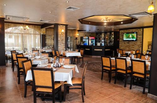 a restaurant with tables and chairs and a bar at Hotel Alegra in Velingrad