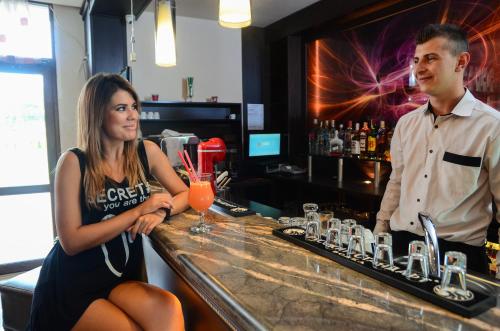 a man and a woman sitting at a bar at Hotel Alegra in Velingrad