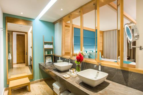 a bathroom with two sinks and a large mirror at Dreams Playa Mujeres Golf & Spa Resort - All Inclusive in Cancún