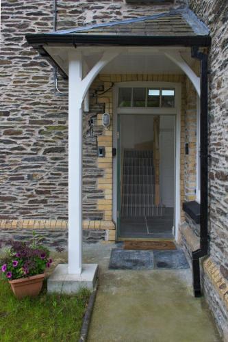 a front door of a brick house with a white pillar at Old School B & B in Llandysul