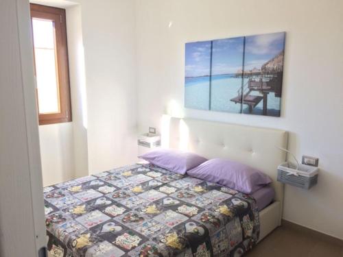una camera con un letto e una foto appesa al muro di Casa Margherita a Quartu SantʼElena