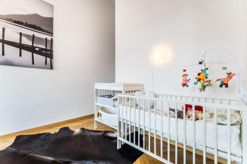 a white baby room with a crib and a painting at BpR Luxe de Noir et Blanc Apartment in Budapest
