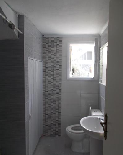 a bathroom with a toilet and a sink and a window at Iris Villa in Apolpaina