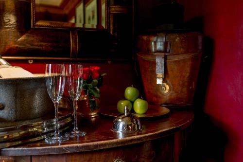 two wine glasses and a bowl of apples on a table at Prestonfield House in Edinburgh