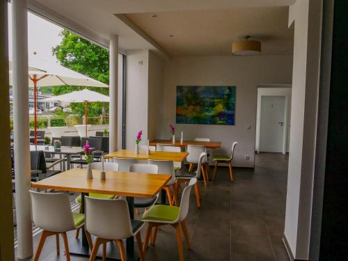 un restaurante con mesas y sillas y una gran ventana en Gleiseins, en Naila