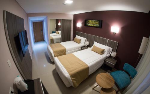 Mérit Iguazú Hotel tesisinde bir odada yatak veya yataklar