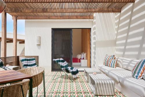 a living room with a couch and a table and chairs at Hotel San Cristobal Adults 15+ in Todos Santos