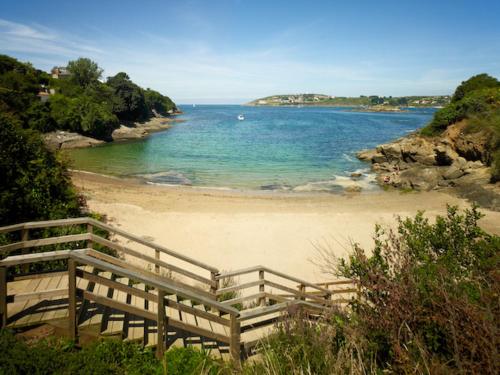 a beach with a wooden fence next to the ocean at Cabañas de Canide in A Coruña