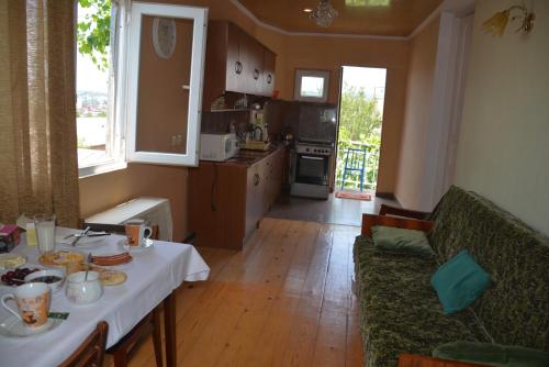 a living room with a table and a kitchen at Friends House in Kutaisi