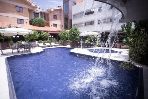 uma piscina com uma fonte num edifício em Las Ventanas Hotel Boutique em Ciudad del Este