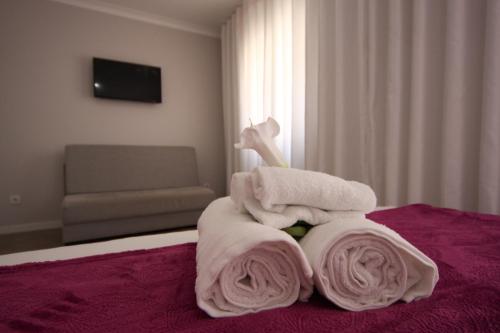 a pile of towels sitting on top of a bed at FerhouseDreams-Praia in Nazaré