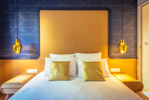 a bedroom with a bed with yellow and blue walls at The Originals Boutique, Hôtel Le Londres, Saumur in Saumur