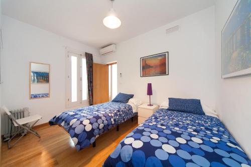 two beds in a room with white walls and blue at La Casa del Conde de Gelves Apartments in Seville