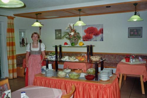 a woman standing in front of a table with food at Landhotel Eibl in Röhrnbach