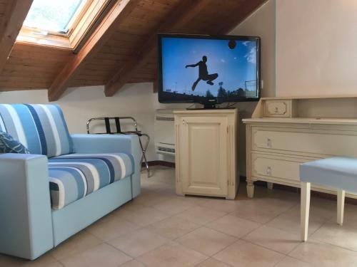 a living room with a couch and a flat screen tv at Hotel Souvenir in Monterosso al Mare