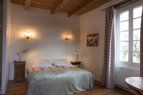 Mirandol-BourgnounacにあるLa Maison de la Souqueのベッドルーム(ベッド1台、窓付)