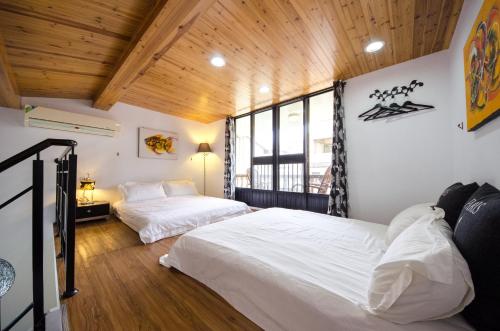台南的住宿－南筑雅室－成功大學，配有木天花板的客房设有两张床。